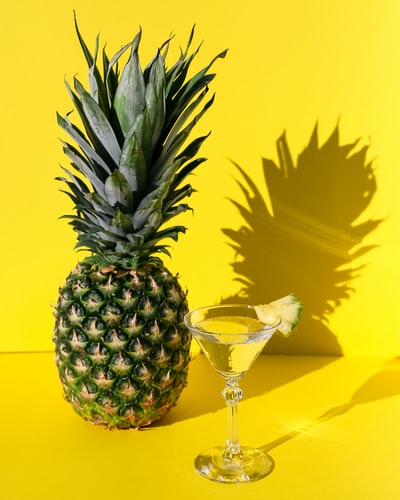 透明酒杯旁的菠萝